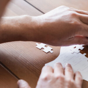 Cropped view of blurred man with dementia folding puzzle, banner Cropped view of blurred man with dementia folding puzzle, banner