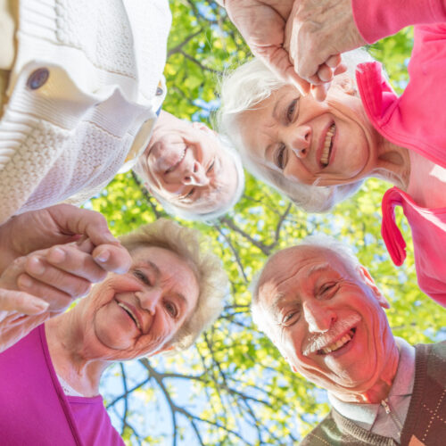 Upward view of two elder couples smiling to the camera. Happines Upward view of two elder couples smiling to the camera. Happiness and retirement concept.